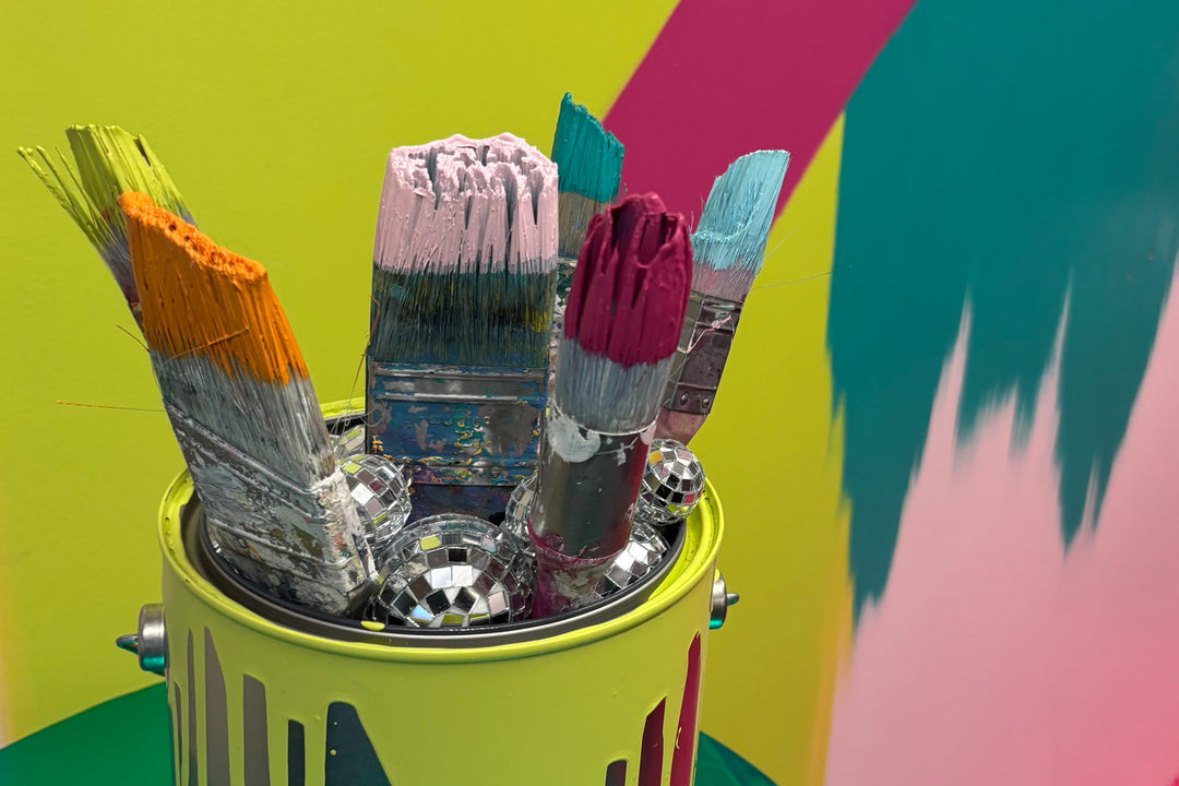 Neon paint brushes in a dripping bucket